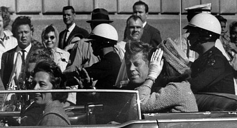 This Nov. 22, 1963 file photo shows President John F. Kennedy riding in motorcade with first lady Jacqueline Kenndy in Dallas, Texas. 