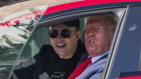 US President Donald Trump and Tesla CEO Elon Musk speak to reporters as they sit in a red Model S Tesla vehicle on the South Lawn of the White House, March 11, 2025, in Washington.
