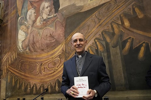 A top friend and ally of the pope Cardinal Victor Fernandez poses for photographers with a copy of a book by Pope Francis titled "Viva la Poesia" (long live poetry) during its presentation to the journalists in Rome, Friday, March 21, 2025.
