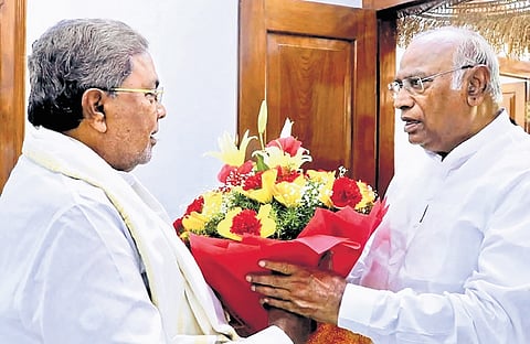 AICC president Mallikarjun Kharge greets Chief Minister Siddaramaiah at the latter’s residence in Bengaluru on Sunday.