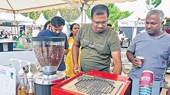 People check a stall at the Coffee Santhe at Freedom Park.
