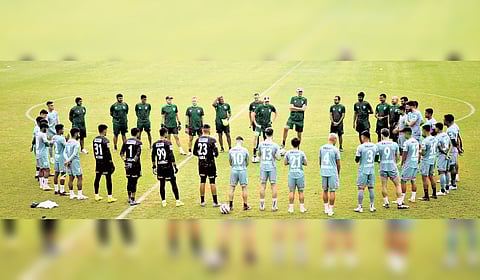 Kerala Blasters players in a huddle during a training session.