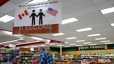 A shopper at the Point Roberts International Marketplace inspects a bag of oranges Tuesday, March 18, 2025, in Point Roberts, Washington.