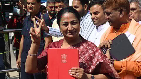 Delhi CM Rekha Gupta shows a folder containing budget papers as she arrives at the Vidhan Sabha to present the Delhi Budget 2025-26 in the Assembly.