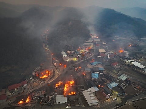 Houses burn in a village after being engulfed by a wildfire fueled by strong winds in Uiseong, South Korea, Tuesday, March 25, 2025.