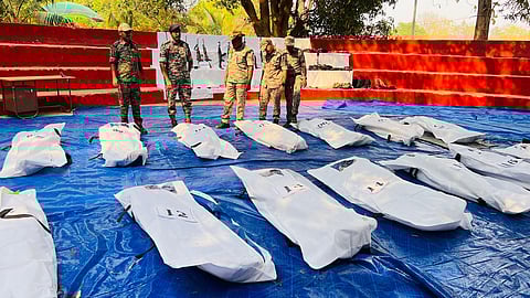 Senior police officers in Bastar looking at recovered weapons, bodies.