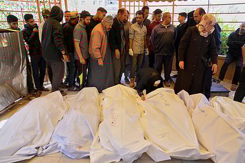 Mourners walk by the bodies of the Abu Sultan family, killed when an Israeli army strike hit their tent before their burial at the hospital in Khan Younis, southern Gaza Strip, Sunday, March 30, 2025.