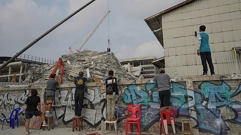 People watch rescue work underway at the site of an under-construction high-rise building that collapsed on Friday after an earthquake in Bangkok, Thailand, Sunday, March 30, 2025.