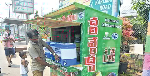 Residents drink water from the VMC kiosk in Vijayawada 