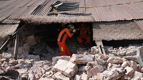 A rescuer works through rubble of a collapsed building following Friday's earthquake in Naypyitaw, Myanmar, Tuesday, April 1, 2025.