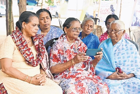 Munambam protesters eagerly watch the live debate on the Waqf Amendment Bill on mobile phone on Wednesday on the premises of Our Lady of Velankanni Church, Kadappuram 
