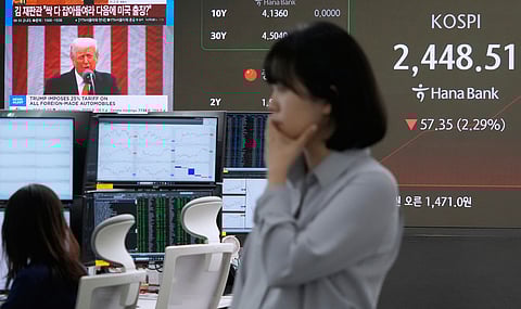 US President Donald Trump is seen on a screen as a currency trader works at the foreign exchange dealing room of the KEB Hana Bank headquarters in Seoul, South Korea. 