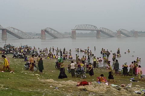 In this photo from April 7, 2025, people clean debris from damaged buildings in the aftermath of an earthquake on March 28 in Naypyitaw, Myanmar.