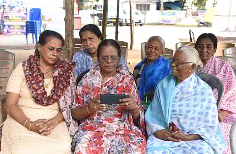 Munambam protesters eagerly watch the live debate on the Waqf Amendment Bill on mobile phone on Wednesday on the premises of Our Lady of Velankanni Church, Kadappuram 