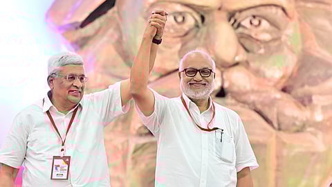 Newly elected sixth General Secretary of CPM, M A Baby, raises hands with former General Secretary Prakash Karat at the Madurai party congress venue
