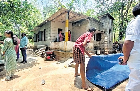 Neighbours tying tarpaulins in front of the family’s home in Kayaramkode village, Palakkad, on Monday
