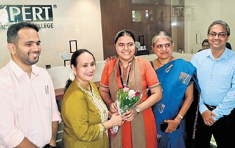 Family members celebrate with Amoolya Kamath, who secured 599 out of 600 and topped the state in the Science stream 