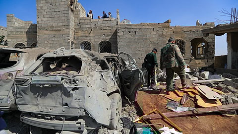 Huthi rebel fighters inspect the site of a reported US airstrike in Sanaa, a day after the attack, on April 7, 2025