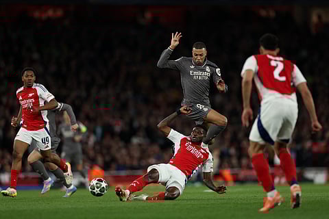 Real Madrid's French forward #09 Kylian Mbappe battles for the ball with Arsenal's Ghanaian midfielder #05 Thomas Partey during the UEFA Champions League Quarter final first leg football match between Arsenal and Real Madrid, at the Emirates Stadium, in London, on April 8, 2025.