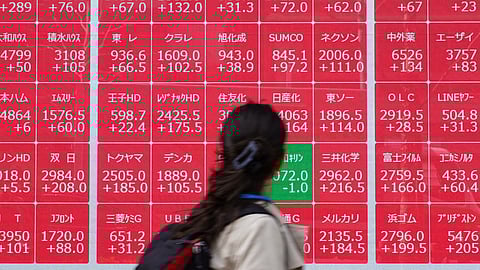A woman looks at an electronic board showing the Nikkei 225 index on the Tokyo Stock Exchange in Tokyo on April 8, 2025. 