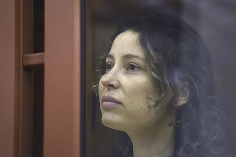 Ksenia Karelina sits in a glass cage in a court room in Yekaterinburg, Russia, Thursday, August 15, 2024.