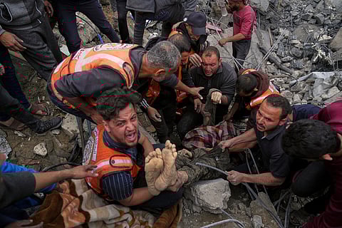 A dead man is removed from the rubble of the Manoun family's house after it was targeted by an Israeli army strike in Jabalia al-Balad, Gaza City, Sunday, April 13, 2025.