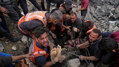 A dead man is removed from the rubble of the Manoun family's house after it was targeted by an Israeli army strike in Jabalia al-Balad, Gaza City, Sunday, April 13, 2025