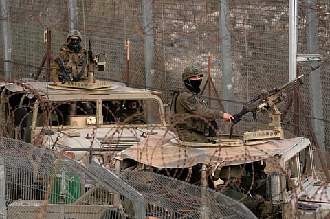 Israeli soldiers stand on armored vehicles after crossing the security fence near the so-called Alpha Line that separates the Israeli-controlled Golan Heights from Syria, in the town of Majdal Shams, Dec. 21, 2024.