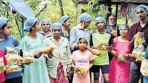 Children with packets of jackfruit chips at Chemmanthatta