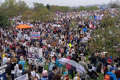 Demonstrators hold up banners during a 'Hands Off!' protest against President Donald Trump at the Washington Monument in Washington, Saturday, April 5, 2025. 