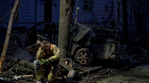 A rescue worker rests near university building destroyed by a Russian missile strike on Sumy, Ukraine, Sunday, April 13, 2025