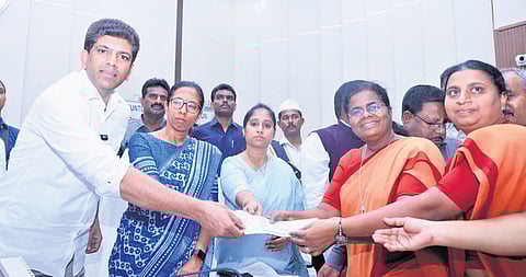Union Minister P Chandrasekhar handing over cheques to affected people.