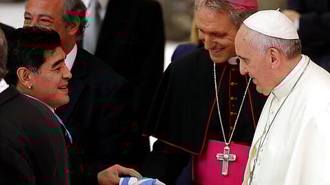 Argentine soccer legend Diego Armando Maradona, left, greets Pope Francis in the Paul VI hall at the Vatican, Monday, Sept. 1, 2014.