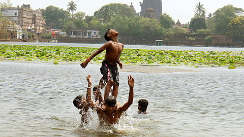 Children enjoying baths in Bindu Sagar to beat the heat on Monday afternoon in Bhubaneswar.