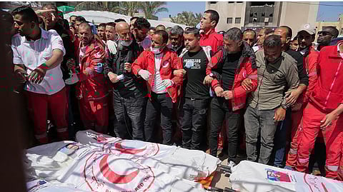 Mourners gather around the bodies of 8 Red Crescent emergency responders, recovered in Rafah a week after an Israeli attack, as they are transported for burial from a hospital in Deir al-Balah, Gaza Strip, on Monday, March 31.