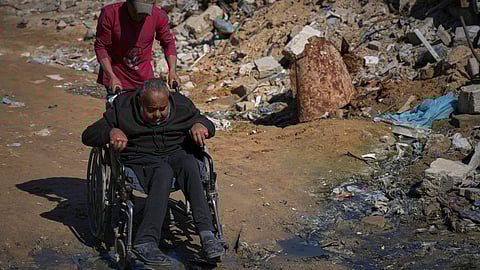 Wasem Attiya pushes his father, Mohamed, 54, in a wheelchair as they head to Shifa hospital in Gaza City for a dialysis session, Monday, April 14, 2025