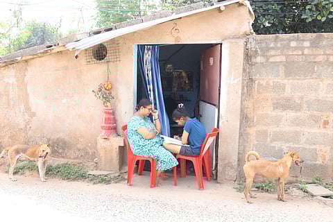 A girl studies outside her home in Bhubaneswar on Tuesday as soaring temperatures make it too hot to stay indoors. Her mother keeps her company