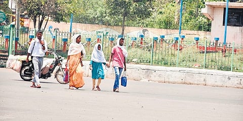 A handful of commuters walk on a deserted road in Rourkela on Thursday.