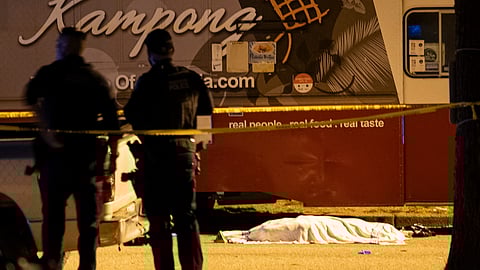 A victim covered with a cloth lies near a food truck after a car drove into a crowd at the Lapu Lapu Festival in Vancouver, British Columbia, Saturday April 26, 2025.