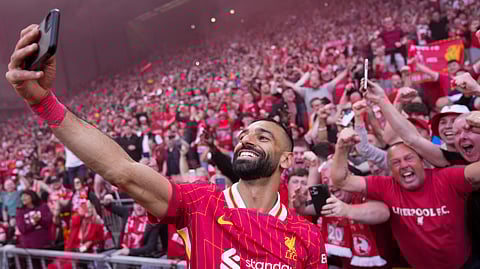 Liverpool's Mohamed Salah celebrates by taking a selfie after winning the EPL soccer match between Liverpool and Tottenham Hotspur and clinching the Premier League title at Anfield in Liverpool, England, Sunday, April 27, 2025.