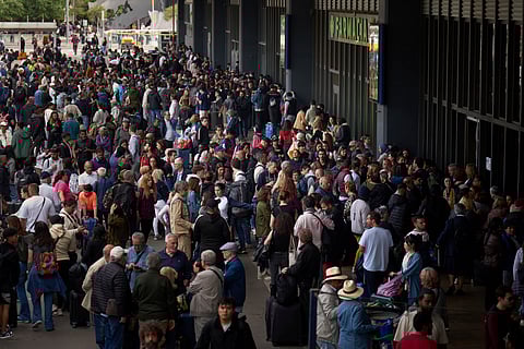 People wait outside a closed train station, during a major power outage in Barcelona, Spain, Monday, April 28, 2025.