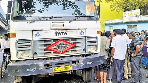 People gather around the lorry involved in the accident in Vijayanagar
