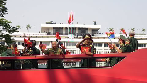 Vietnam War veterans on an open bus pass the Independence Palace during a parade to commemorate the 50th anniversary of the end of the Vietnam War in Ho Chi Minh City Wednesday, April 30, 2025. 