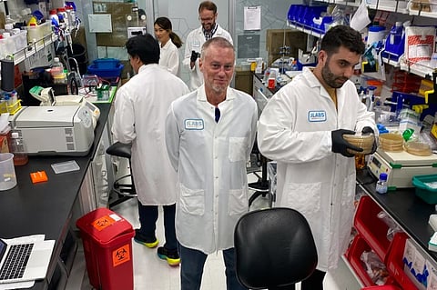 In this photo provided by Centivax, Tim Friede, center, stands in a lab in South San Francisco, Calif., in 2023, that is using his blood to prepare an antivenom to the bites of various snakes.