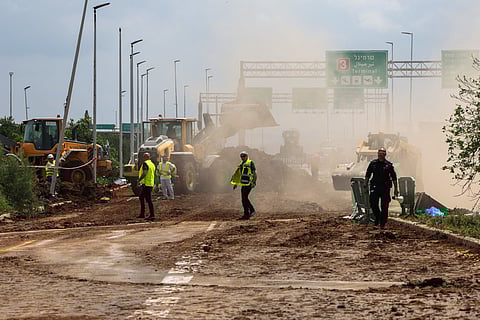 Israeli emergency services clear a road outside Israel's Ben Gurion airport after a missile launched from Yemen struck near the facility on May 4, 2025.