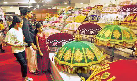 Visitors take a close look at the umbrellas exhibited at the Chamaya Pradarshanam of Thiruvambady.