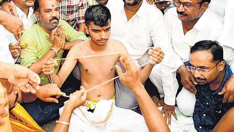 NEET candidate Sripad Patil wears a new janivara amid chanting of mantras by priests on the road in front of St Mary’s School in Kalaburagi on Sunday