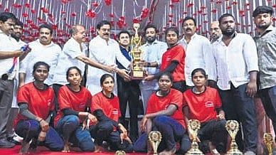 The winning team poses with the trophy. 