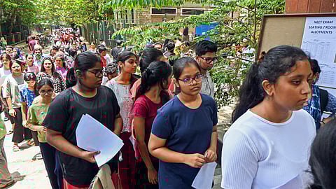 FILE | Aspirants wait to appear for the NEET UG exam, in Bengaluru.