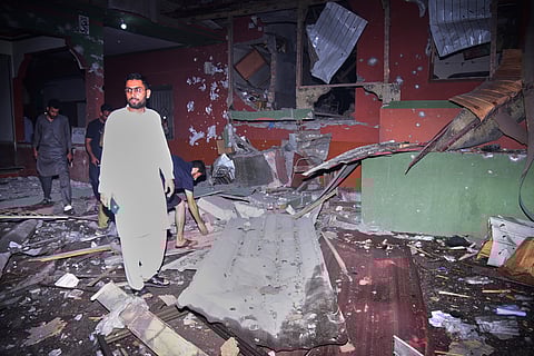 Local residents examine a building damaged from a suspected Indian missile attack near Muzaffarabad, the capital of Pakistan controlled Kashmir, in Wednesday, May 7, 2025.